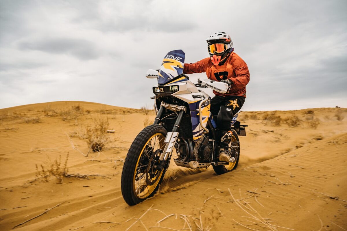Braucējs ar KOVE rallija motociklu smiltīs